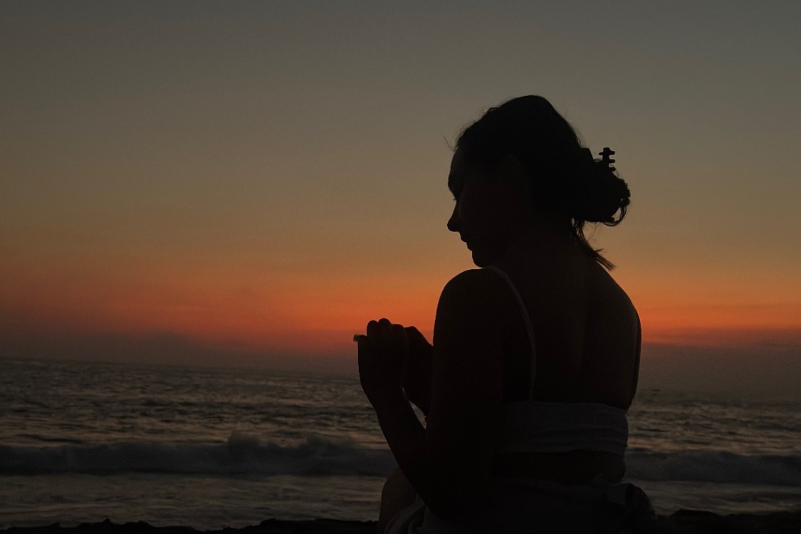 Silueta de Esme frente al mar al atardecer