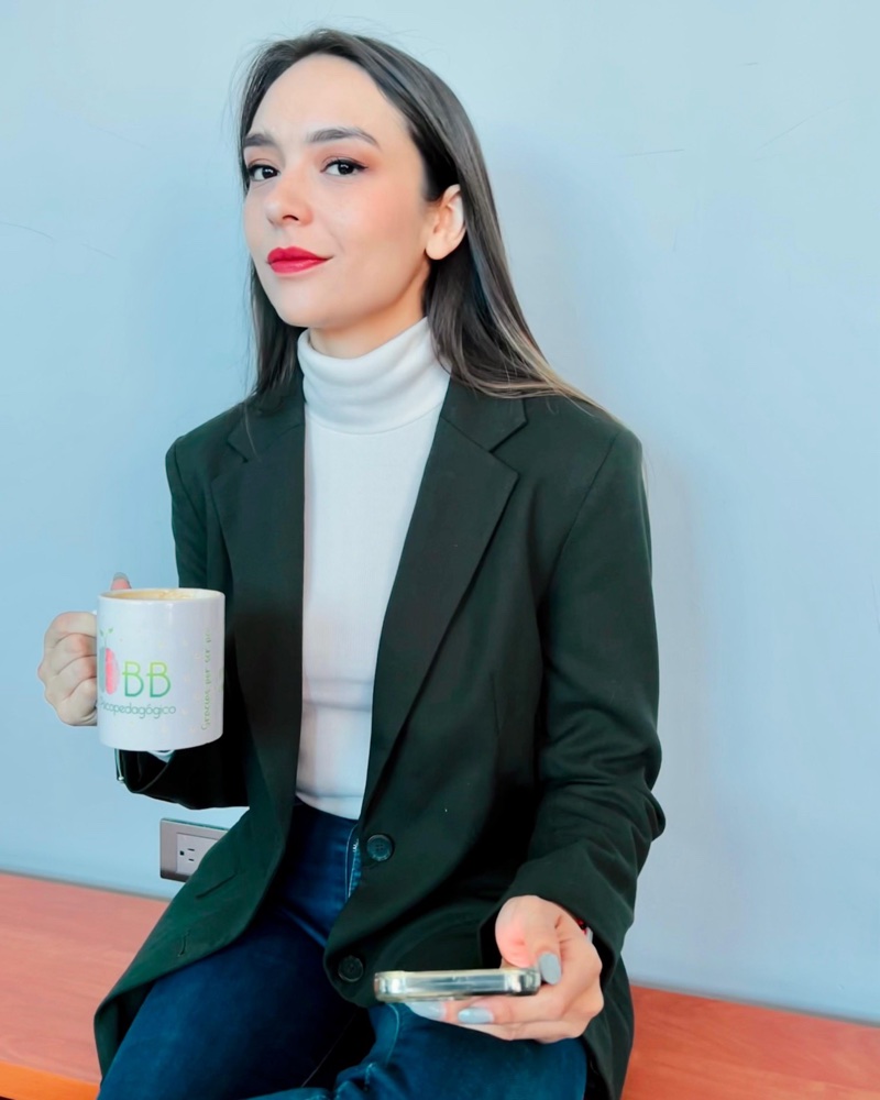 Mtra. Esme Malagón con una taza del Centro Psicopedagógico Robb